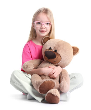 Little girl hugging her teddy bear on white background