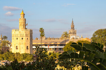 Seville, Andalusia, Spain: The historic Torre del Oro stands majestically along the Guadalquivir River, with a charming tourist boat docked nearby under a clear sky, showcasing Seville' © Sodel Vladyslav