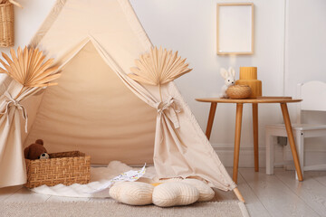 Stylish wigwam with dry leaves in child's room © New Africa