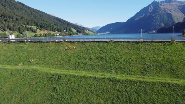 Aerial drone view of Resia Lake dam: sustainable hydroelectric power infrastructure, Renewable energy production, and environmental engineering in the Italian Alps landscape