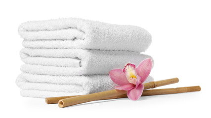 Clean folded towels, spa massage bamboo sticks and orchid flower isolated on white