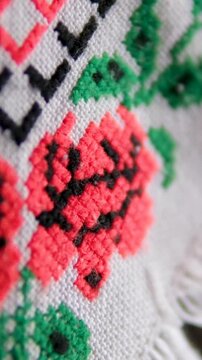 Traditional Ukrainian embroidered white doily with red and black roses and green leaves hanging on cabinet showcasing folk heritage and rustic vintage home decor