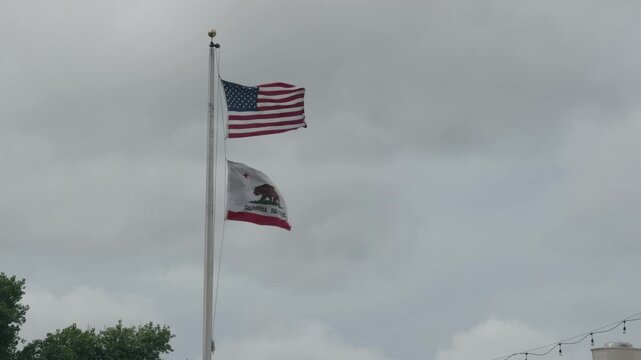 The United States and California state flags wave from a  flagpole