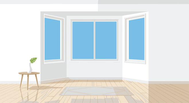 An empty sunlit room showcases a large three-pane bay window overlooking a blue sky with a small wooden side table and grey geometric rug on the floor.