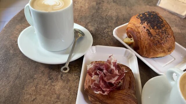 Two cups of coffee latte croissants pastries buns on a wooden table breakfast for two