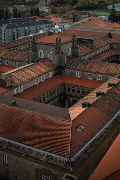 Aerial view of a historic cloister with red tile roofs and an inner courtyard