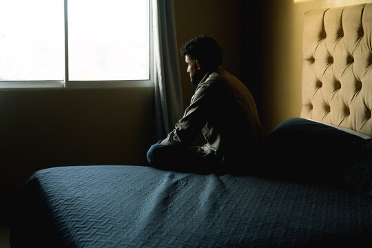 Man feeling worried and thinking by window