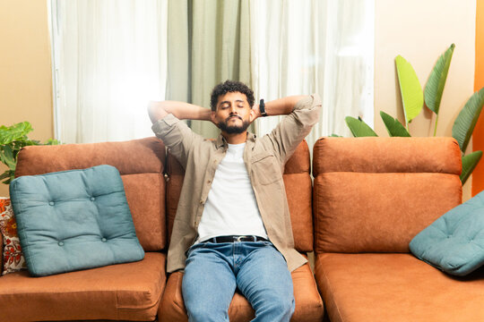 Man is relaxing on comfortable couch at home.