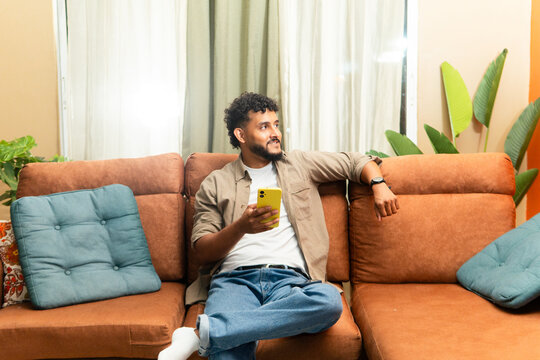 Young man relaxing lying on a couch at home.
