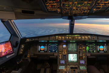 Airplane cockpit view above clouds at sunset with instruments © Thomas