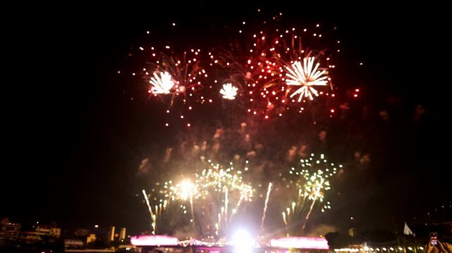 New year's eve fireworks on the night sky over the river city celebration loop of real fireworks show background