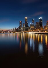 Obraz premium Illuminated modern skyscrapers rise above dark water reflecting city lights during twilight