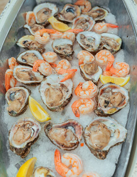 Fresh oysters and shrimp served on ice with lemon wedges