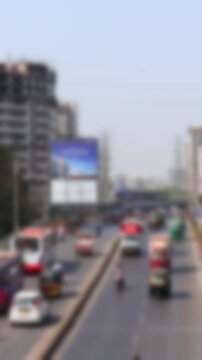 Busy road traffic on Ramakrishna Chemburkar Marg near monorail train station Chembur in Mumbai, India. Top angle view. Blurry real time motion video for background.	