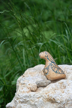 Old stone figurine of mythology women bird creature on nature background. magical creature with head and breasts of woman but body of birds. Siren pagan greek or slavic mythology spirit Alkonost bird