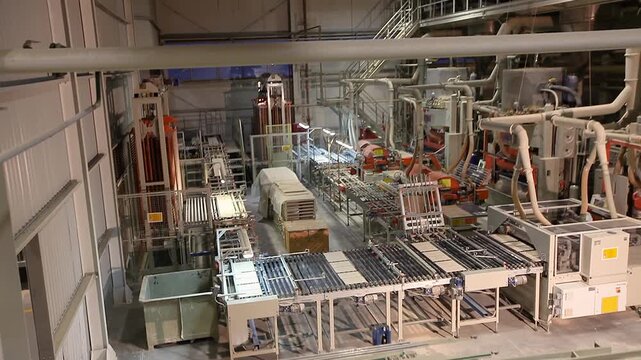 A production or conveyor line at a ceramic and porcelain tile factory. Manufacturing process of ceramic tiles. The process of making ceramic tiles. Conveyer line for ceramic tile at plant. 