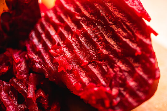 Macro shot of grated red beetroot for salad or borscht. Healthy organic vegetable texture. Fresh shreds of boiled beet. Perfect for cooking recipes and nutrition
