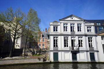 Parkanlage mit Kaimauer und prächtiger weißer Altbau im Stil des Neoklassizismus im Frühling bei Sonnenschein am Kanal in der Altstadt von Brügge in Westflandern in Belgien  © Martin Debus