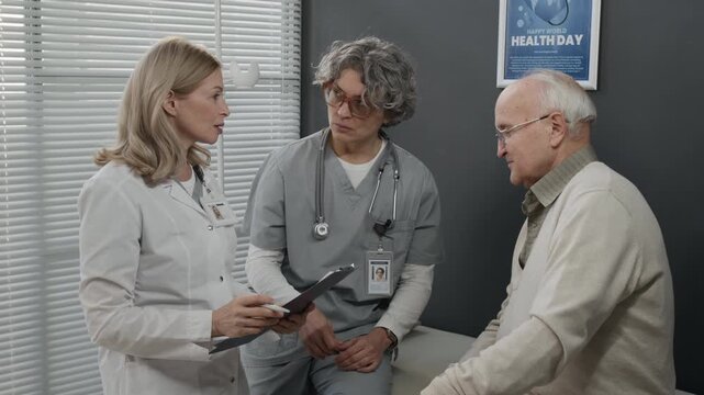 Two mature Caucasian female doctors working with senior male patient, discussing check up results and giving recommendations