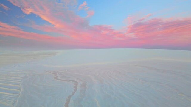 Vibrant pink sunset colors illuminate gypsum dunes in White Sands National Park New Mexico