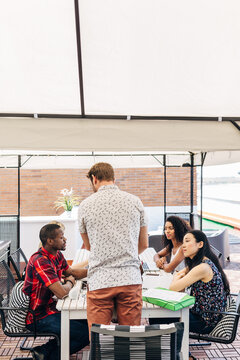 Diverse coworkers collaborating at outdoor office meeting