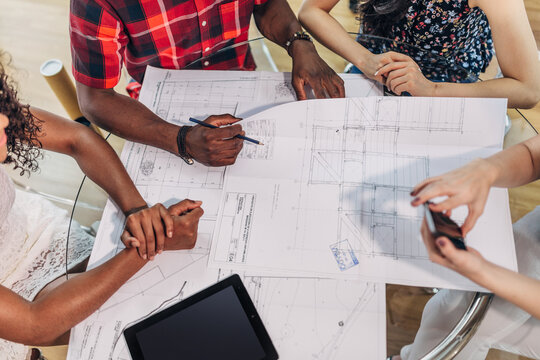 Team reviewing architecture blueprint at meeting table