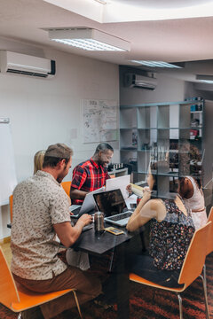 Diverse team meeting with laptops in modern office room