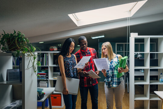 Diverse colleagues reviewing documents in modern office
