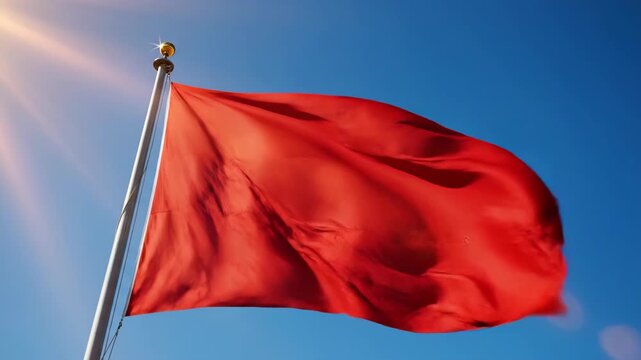 Red Flag Waving Against a Clear Blue Sky in Bright Daylight