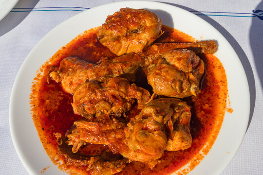 Stewed rabbit in red mojo sauce on a table in restaurant. Canarian cuisine