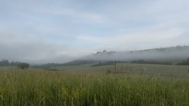 Tocnik castle early morning panorama with fog over surrounding fields and meadows Czech landscape landmark