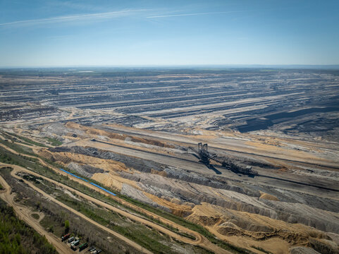 High angle aerial view of a massive machines digging for lignite coal in an open pit mine