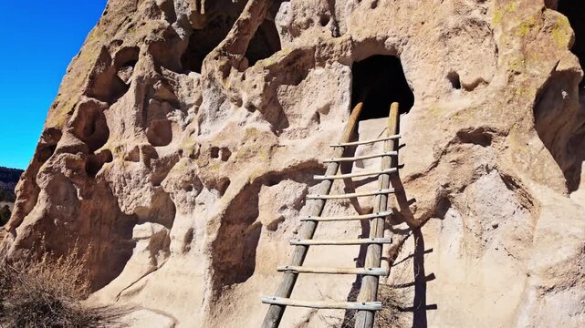 Scenic view of ancient settlements carved into rock cliffs at Bandelier National Monument in New Mexico
