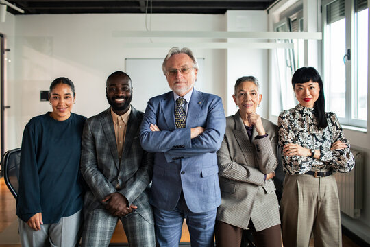 Diverse team of five business professionals in modern office