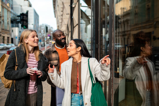 Friends window shopping on city street