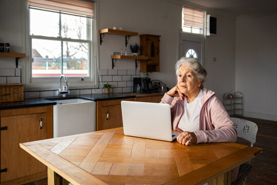 Senior woman using laptop in home kitchen