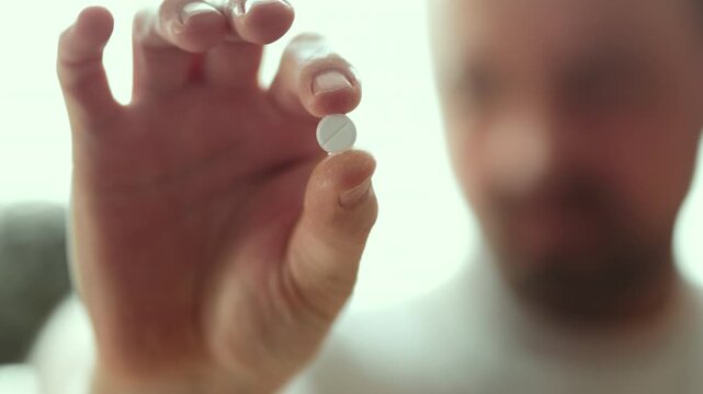Adult Man Looking at White Pill and Taking It with Glass of Water Close Up 4K 10-bit