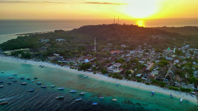 Overhead drone shot of Gili Trawangan nightlife with glowing coastline and dark ocean