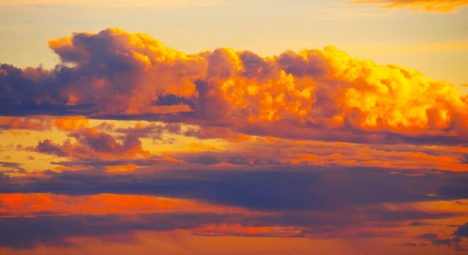 Burning sky with dramatic fluffy clouds and divine rays of light colorful clouds background 
