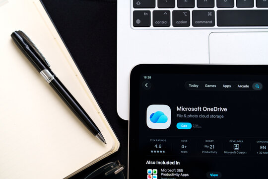 Microsoft OneDrive iPad screen close view with Apple Liquid Glass redesign and iOS 26 styling beside notebook and laptop. Stafford, United Kingdom, April 13, 2026.