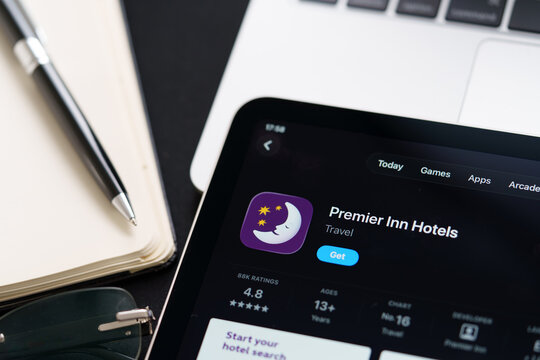 Premier Inn listing on iPad highlights Apple Liquid Glass updated design and iOS 26 look in office desk scene. Stafford, United Kingdom, April 13, 2026.