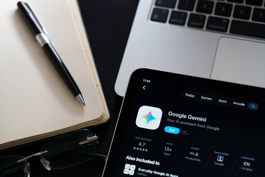 Google Gemini listing on iPad highlights Apple Liquid Glass updated design and iOS 26 look in office desk scene. Stafford, United Kingdom, April 13, 2026.