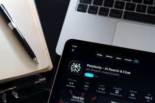 Perplexity app on iPad with Apple Liquid Glass updated look and iOS 26 design on desk beside notebook and laptop. Stafford, United Kingdom, April 13, 2026.