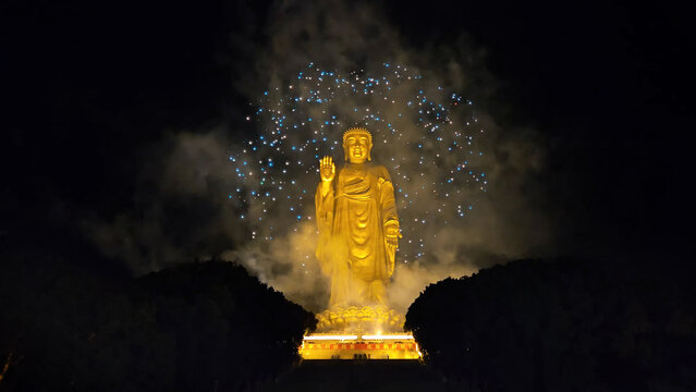 Big buddha statue of Lingshan.  A photo of festive fireworks in night sky. Beautiful light show on
chinese new year eve. Grandiose carnival.
Golden religious sculpture.
