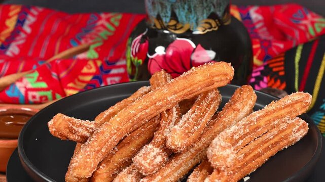 Mexican culinary culture. Sweet churros on a background of colorful textiles