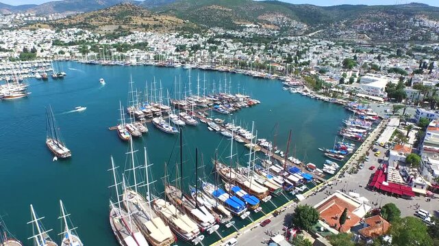 Aerial Bodrum Castle above marina and sea boats on Turkeys Aegean and Mediterranean coast. Turquoise harbor borders an ancient walled citadel as yachts gather beside the sunlit coastal city.