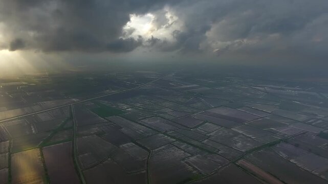 Panoramic aerial view of black storm clouds above flooded plains after heavy rain. French countryside scene shows waterlogged farmland beneath dramatic atmosphere before clearing.