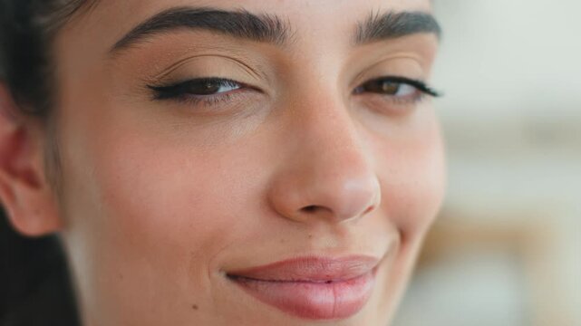 Extreme close up smiling joyful Indian woman at home looking at camera showing healthy skin natural makeup beauty treatment satisfied lady carefree Arabian female businesswoman skincare health indoors