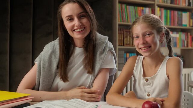 Happy Caucasian little girl child woman teacher giving high five in class celebrating learning success together teamwork lesson education kid schoolgirl school student studying textbook task progress