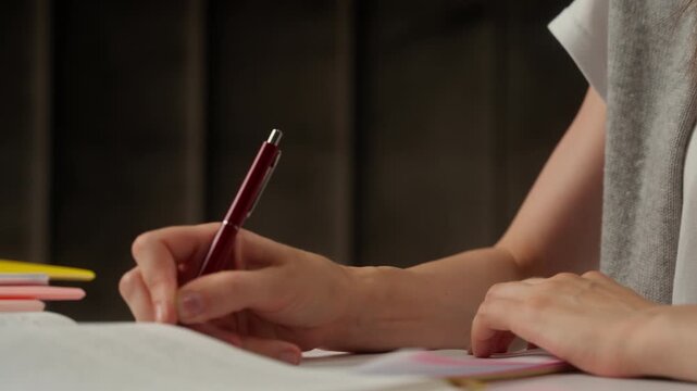 Focused Caucasian woman high school student writing test homework notebook in library female girl businesswoman planning schedule task diary working learning study education classroom teacher indoor